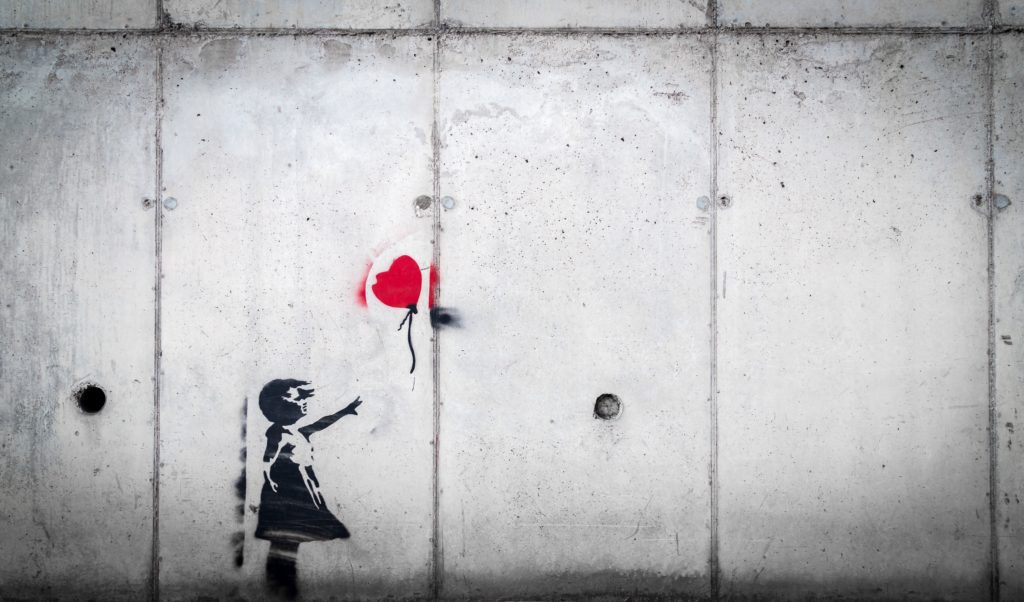 girl losing red heart balloon